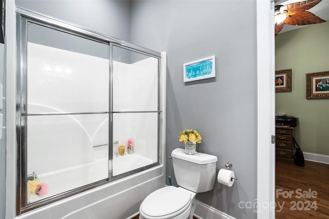 bathroom with ceiling fan, toilet, wood-type flooring, and enclosed tub / shower combo