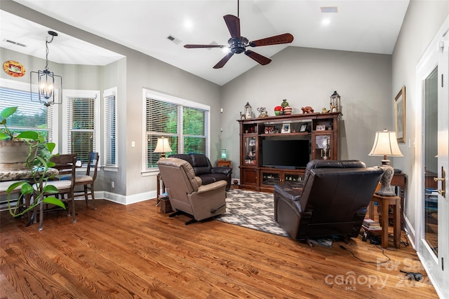 living room with ceiling fan with notable chandelier, lofted ceiling, and hardwood / wood-style floors