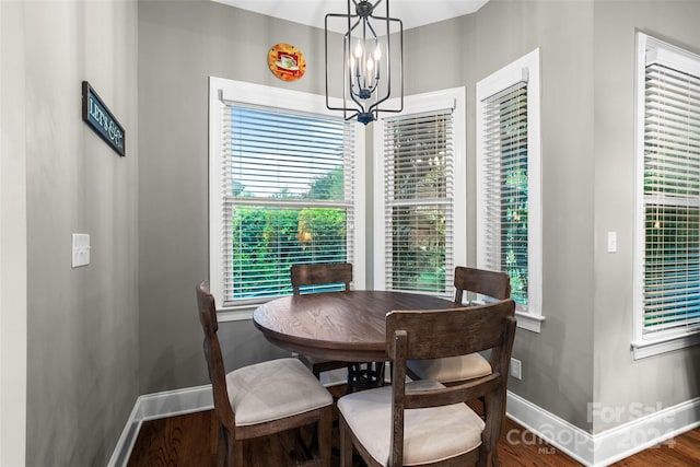 dining area with a notable chandelier, a healthy amount of sunlight, and hardwood / wood-style floors