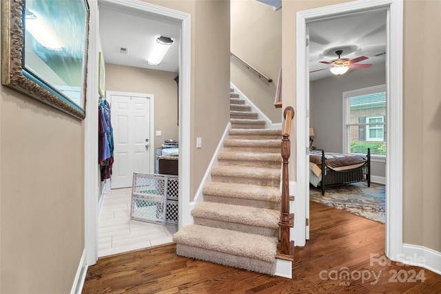 stairway featuring hardwood / wood-style floors and ceiling fan