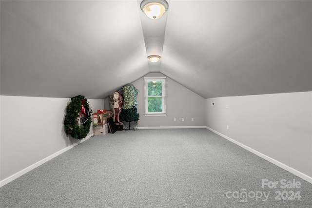 additional living space featuring lofted ceiling and carpet