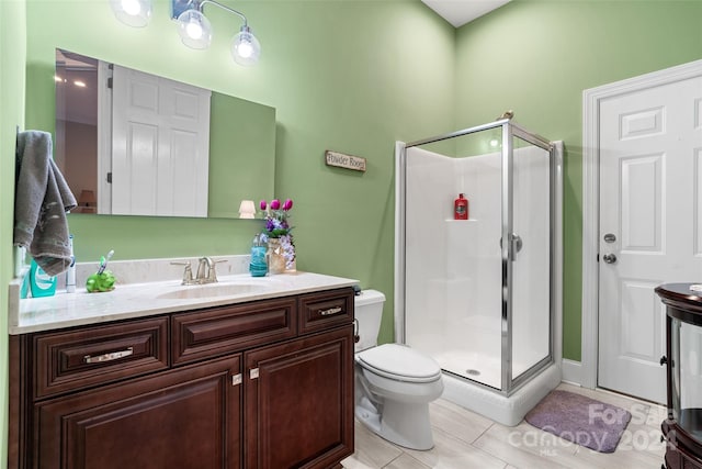 bathroom with toilet, an enclosed shower, tile patterned floors, and vanity