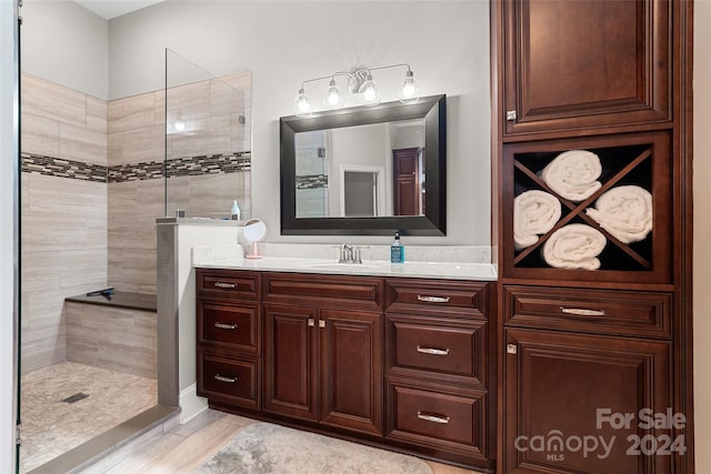 bathroom featuring tiled shower and vanity