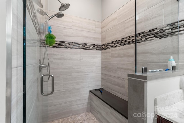 bathroom featuring walk in shower and vanity