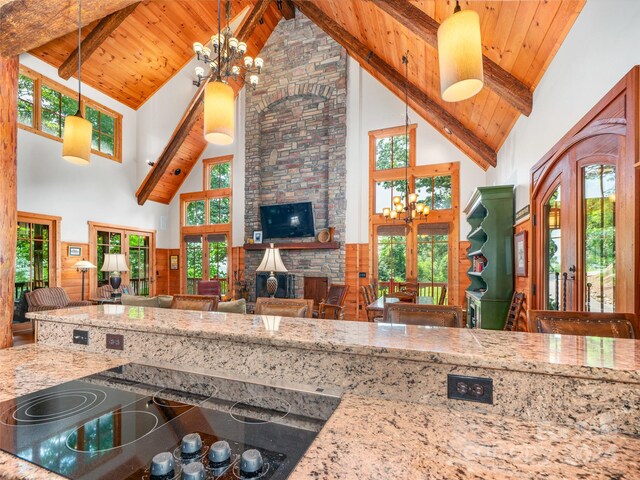 kitchen featuring beamed ceiling, high vaulted ceiling, a notable chandelier, and a healthy amount of sunlight