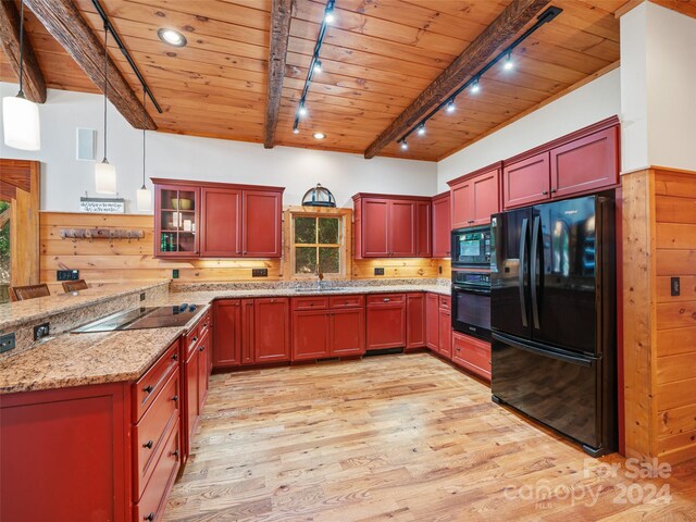 kitchen with light wood-type flooring, black appliances, beamed ceiling, and sink