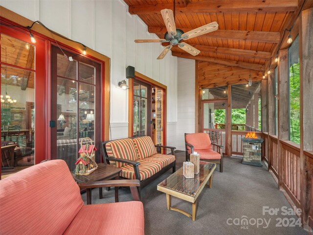 sunroom with wooden ceiling, lofted ceiling with beams, and ceiling fan