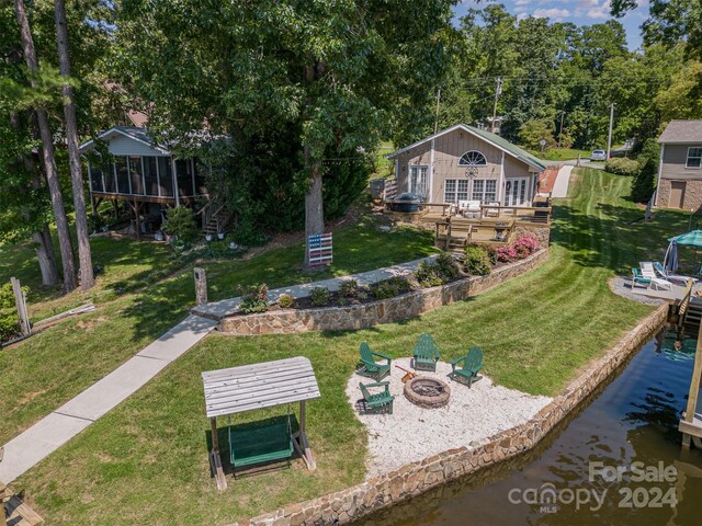 view of yard with a dock, a deck, and an outdoor fire pit