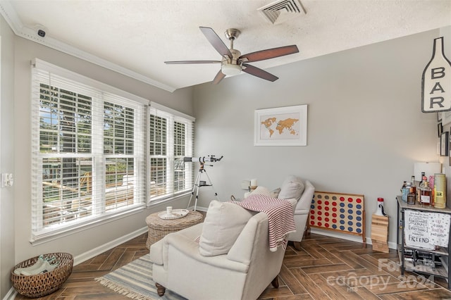 interior space with a textured ceiling, ceiling fan, crown molding, and dark parquet floors