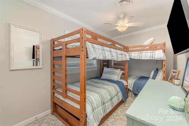 carpeted bedroom with ceiling fan and ornamental molding