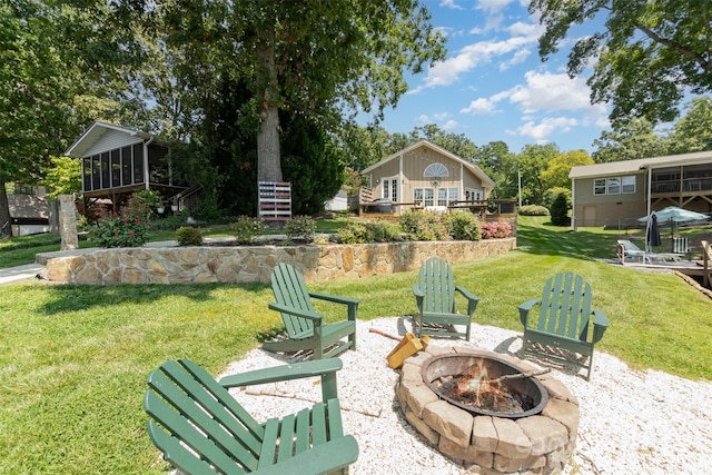 exterior space with a sunroom and a fire pit