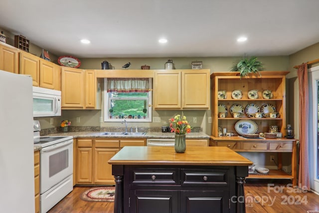 kitchen with a center island, sink, light brown cabinets, wood-type flooring, and white appliances