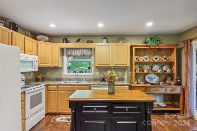 kitchen with white appliances, a kitchen island, a sink, and light brown cabinetry