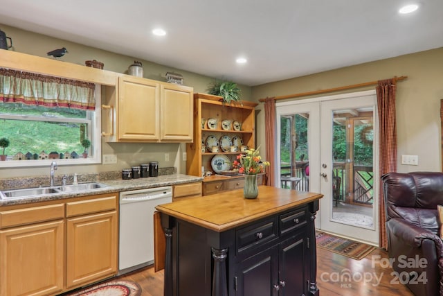 kitchen with a wealth of natural light, sink, white dishwasher, and a kitchen island