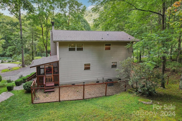 back of house with a shingled roof, crawl space, and a lawn