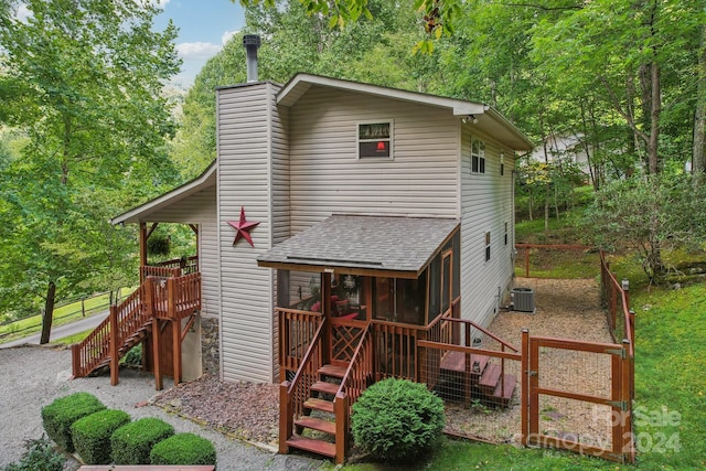 view of jungle gym featuring stairs, a sunroom, and central air condition unit