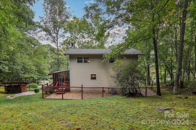 rear view of property with a yard and a sunroom