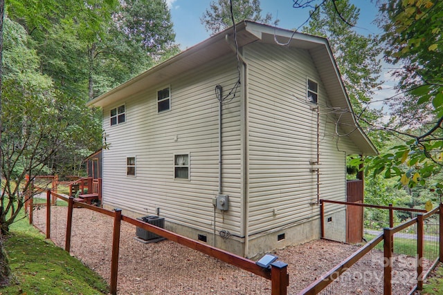 view of home's exterior featuring crawl space and fence