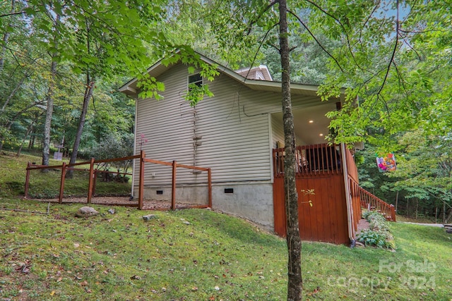 view of property exterior featuring crawl space, stairs, and a lawn