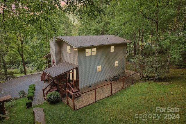 exterior space with central air condition unit, a yard, and a deck