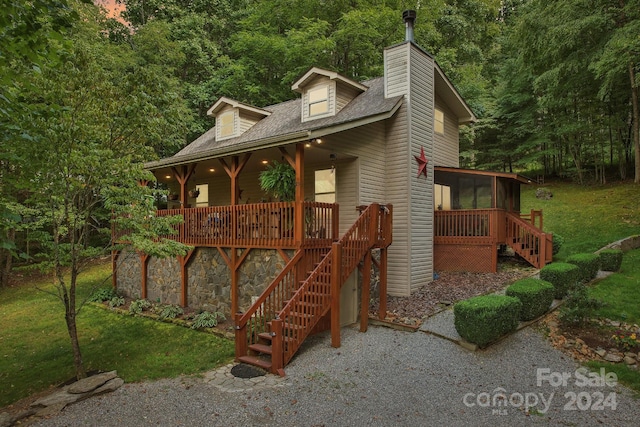 view of front of home with a sunroom and a front yard