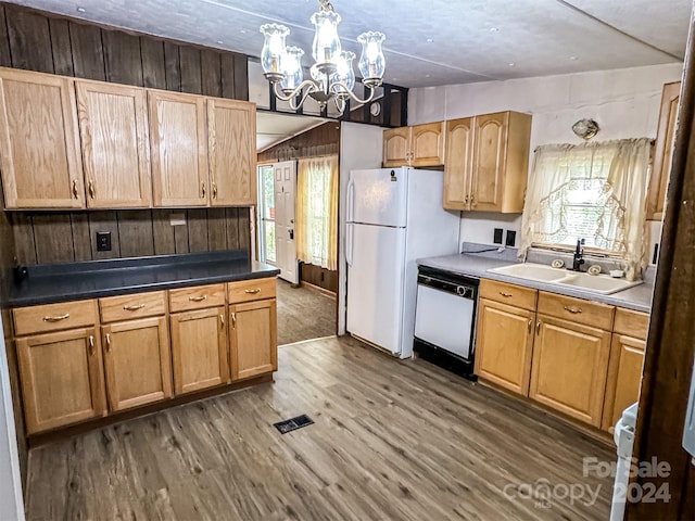 kitchen with sink, white appliances, a notable chandelier, and hardwood / wood-style floors