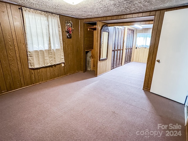 carpeted spare room featuring a textured ceiling