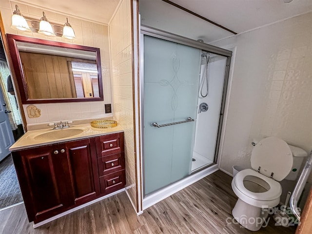 bathroom featuring an enclosed shower, vanity, hardwood / wood-style floors, and toilet