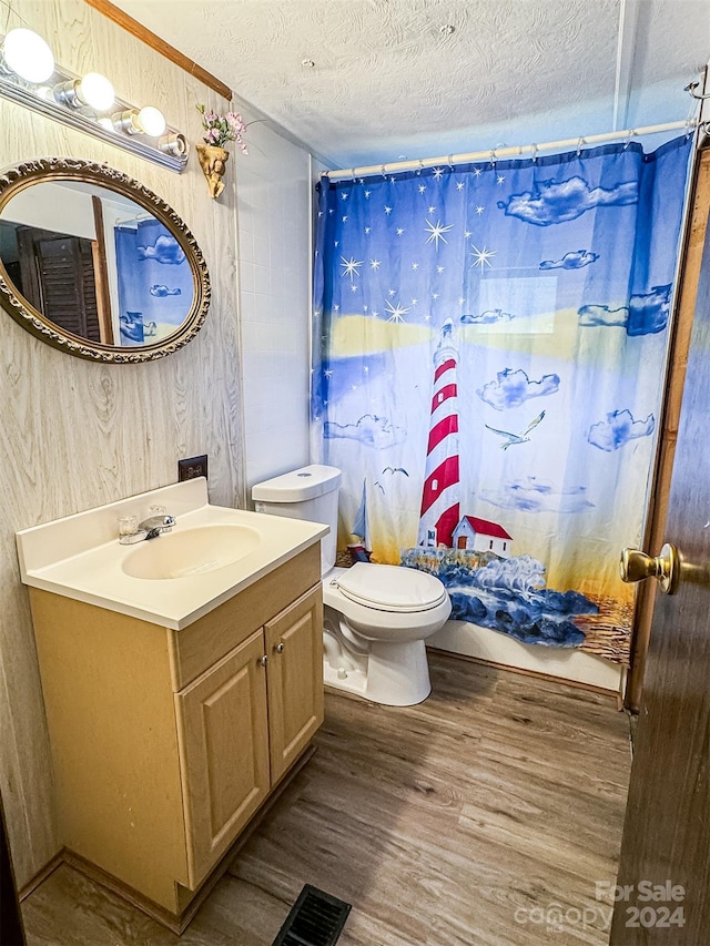 bathroom featuring hardwood / wood-style flooring, toilet, a textured ceiling, and vanity