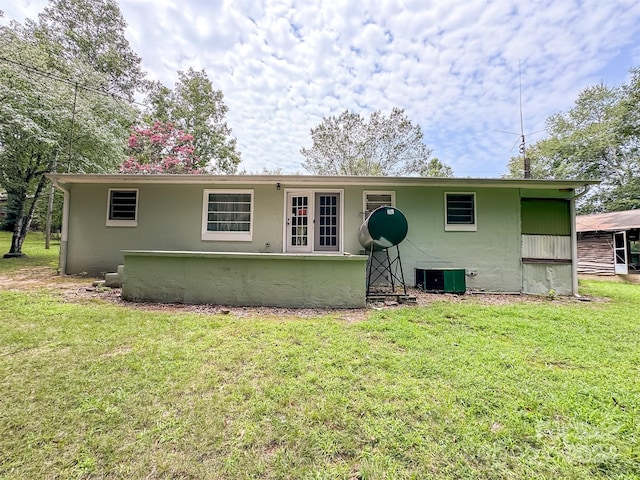 view of front of house featuring cooling unit and a front yard