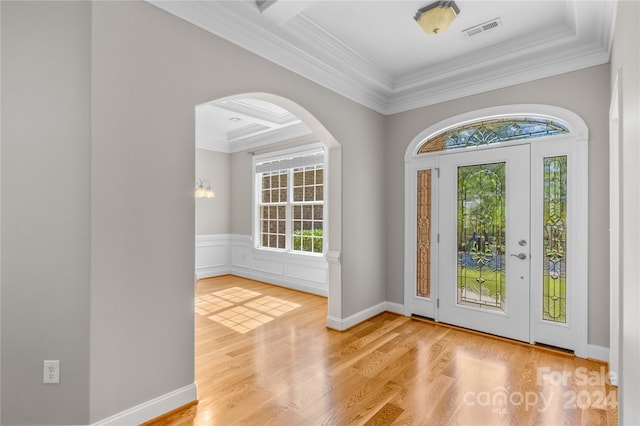 foyer entrance with light wood-type flooring, crown molding, coffered ceiling, and beam ceiling