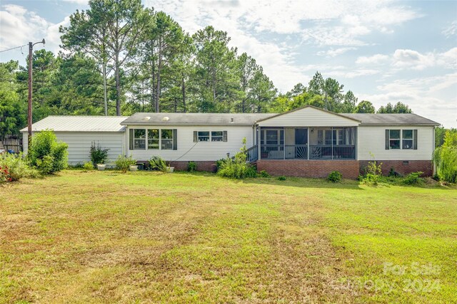 view of front facade with a front lawn and a sunroom