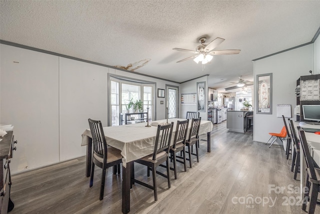 dining room with ceiling fan, crown molding, a textured ceiling, and hardwood / wood-style floors