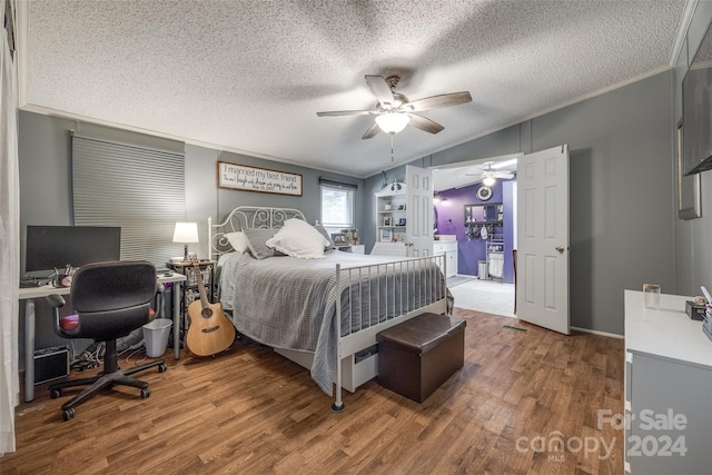 bedroom with lofted ceiling, a textured ceiling, wood-type flooring, and ceiling fan