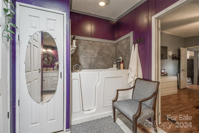 interior space featuring crown molding, a textured ceiling, and wood-type flooring