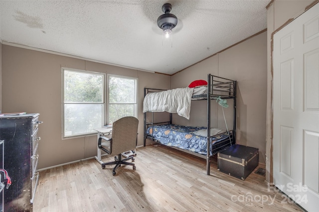 bedroom featuring crown molding, a textured ceiling, light wood-type flooring, and ceiling fan