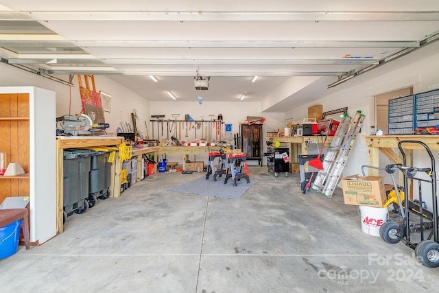 garage with a garage door opener and a workshop area