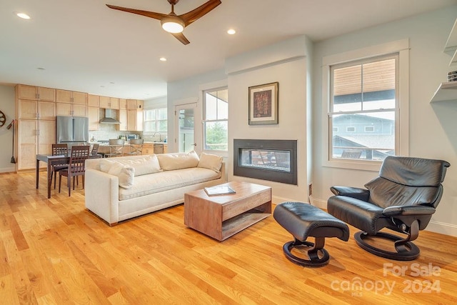 living room featuring ceiling fan and light hardwood / wood-style flooring