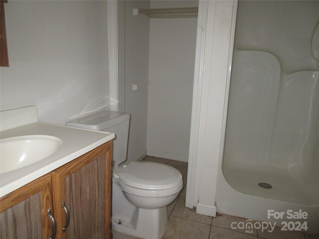 bathroom with vanity, a shower, tile patterned floors, and toilet