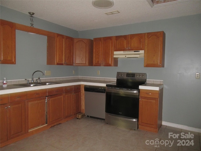 kitchen featuring appliances with stainless steel finishes, sink, and a textured ceiling