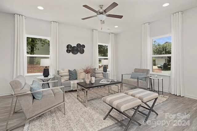 living room featuring ceiling fan, plenty of natural light, and light hardwood / wood-style floors