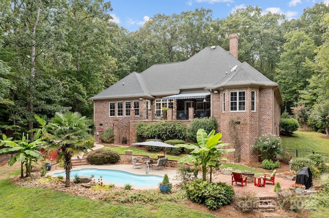 back of house featuring a patio and a fenced in pool