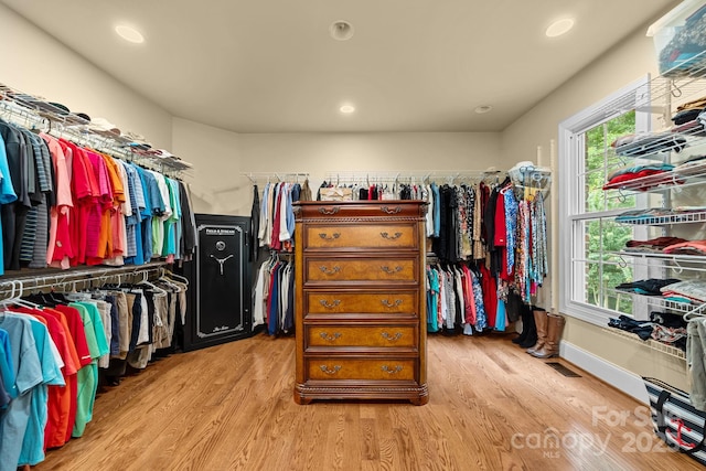 walk in closet with light hardwood / wood-style flooring