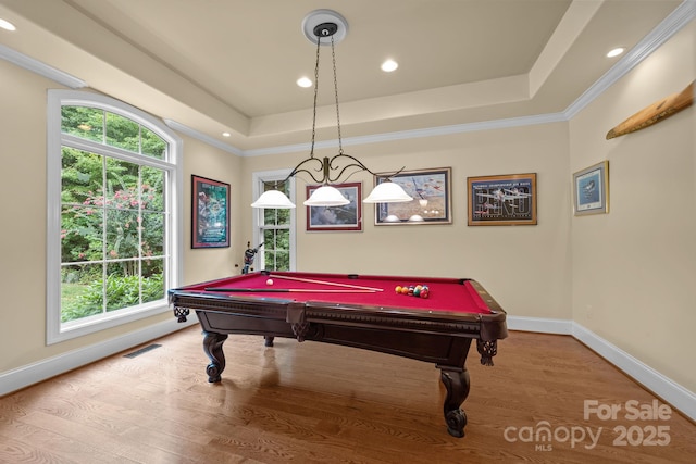 recreation room with a tray ceiling, light hardwood / wood-style floors, a healthy amount of sunlight, and pool table