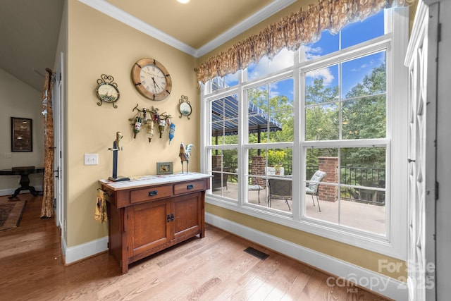 doorway to outside with light wood-type flooring and ornamental molding