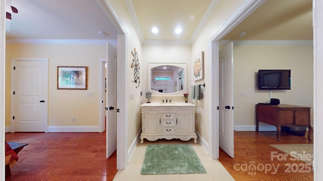 bathroom featuring hardwood / wood-style floors, vanity, and ornamental molding