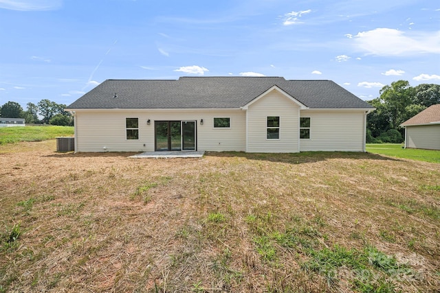 back of property with a yard, central AC, a patio, and roof with shingles