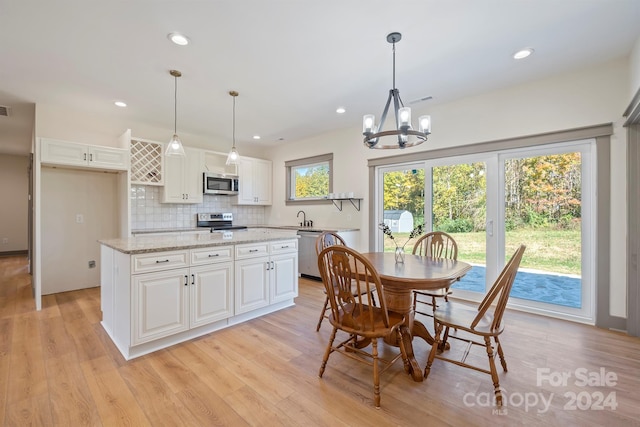 dining area with a chandelier, light wood-type flooring, and recessed lighting