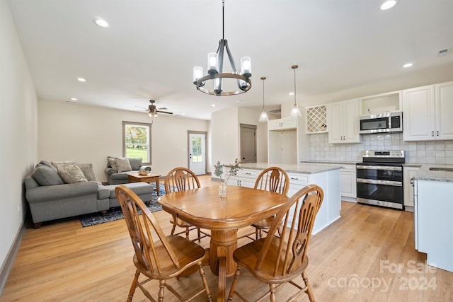 dining space featuring light wood-style floors, recessed lighting, visible vents, and ceiling fan with notable chandelier