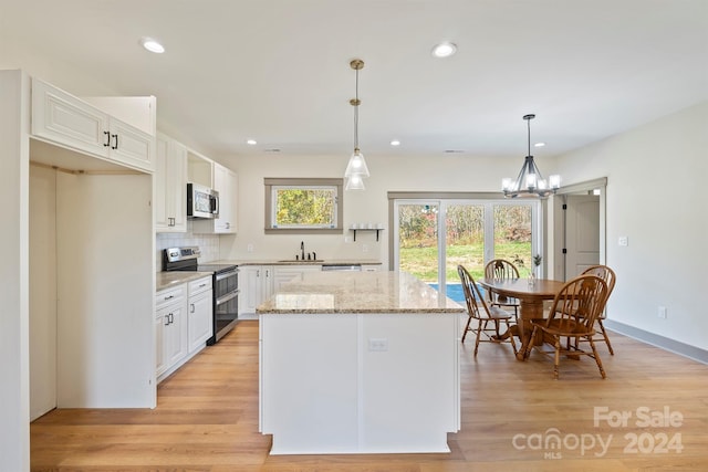 kitchen featuring a center island, white cabinetry, stainless steel appliances, and pendant lighting